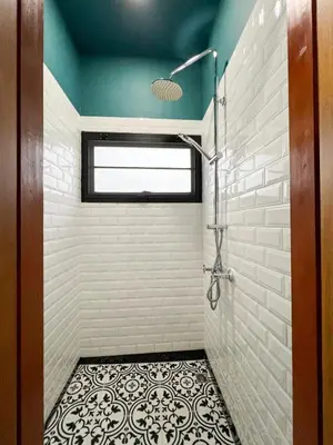 a bathroom with a shower and a tile floor at Poshtel 56 in Bangkok