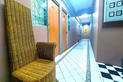 a hallway with a chair in a building at Sukhum Sukhumvit-Onnut Guest House in Amphoe Phra Khanong