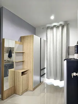 a kitchen with a book shelf and a refrigerator at Hidden Gems Residence in Ban Sala Daeng