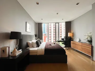 a bedroom with a bed and a desk and a window at Saladaeng Residences at Silom in Bangkok