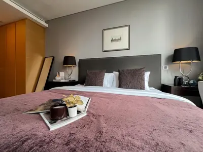 a bedroom with a large bed with a pink blanket at Saladaeng Residences at Silom in Bangkok