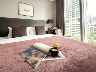 a bedroom with a large bed with a large window at Saladaeng Residences at Silom in Bangkok
