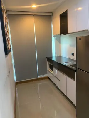 a kitchen with white cabinets and a stainless steel refrigerator at Supalai Wellington 2, near MRT in Sathani Khlong Tan