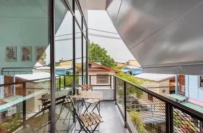 a balcony with a table and chairs on it at Homemade Ice cream house in local village in Bangkok