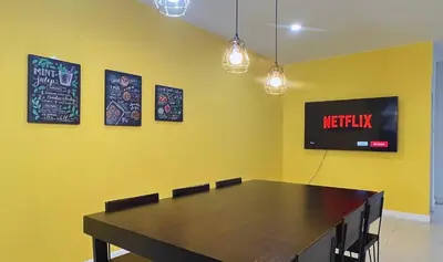 a dining room with a table and a sign on the wall at BTS Asoke 6bedroom townhouse in Bang Kapi