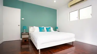 a bedroom with a white bed with blue walls at BTS Asoke 6bedroom townhouse in Bang Kapi
