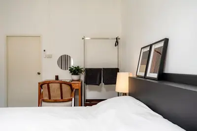 a bedroom with a bed and a table and a mirror at Nap Boriphat in Bangkok