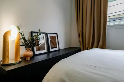 a bedroom with a bed and two pictures on a table at Nap Boriphat in Bangkok