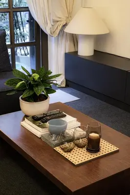 a coffee table with books and glasses and a potted plant at Nap Boriphat in Bangkok