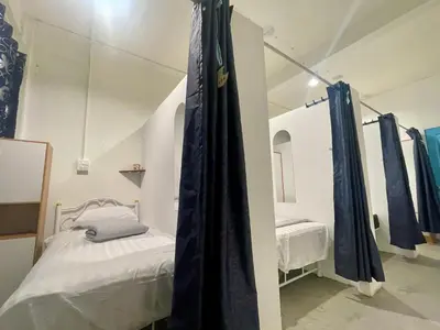 a room with two beds and blue curtains at Moon Pīti in Bangkok