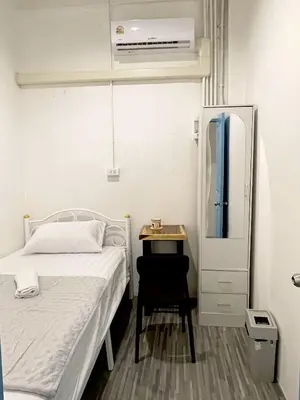 a small bedroom with a bed and a desk at Moon Pīti in Bangkok