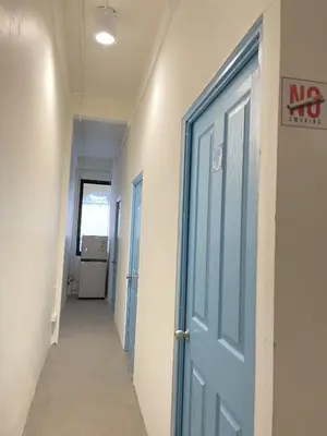an empty hallway with a blue door in a hospital at Moon Pīti in Bangkok