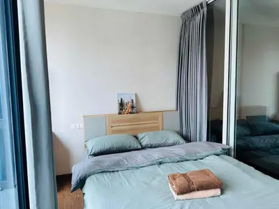 a bedroom with a bed and a large mirror at Artisan Ratchada Prime Studio Condos in Bangkok