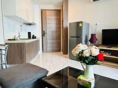 a living room with a vase of flowers on a table at Artisan Ratchada Prime Studio Condos in Bangkok