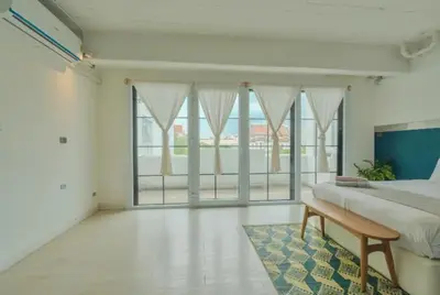 a bedroom with a large bed and a large window at Old Town Heritage Lofts Bangkok in Bangkok