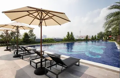 a swimming pool with chairs and umbrellas next to a pool at Artisan Ratchada Huge 1BR Condos in Bangkok