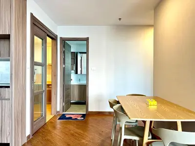 a dining room with a wooden table and chairs at Artisan Ratchada Spacious 2BR Condos in Bangkok