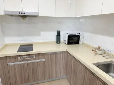 a kitchen counter with a microwave and a sink at Artisan Ratchada Spacious 2BR Condos in Bangkok