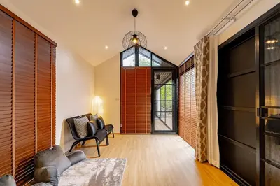 a living room with a couch and a chair at The Lodge Bangkok Poolvilla in Sathani Khlong Tan