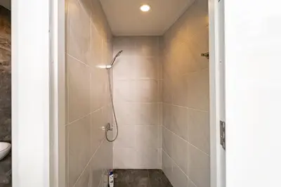 a shower stall in a bathroom with a toilet at The Lodge Bangkok Poolvilla in Sathani Khlong Tan