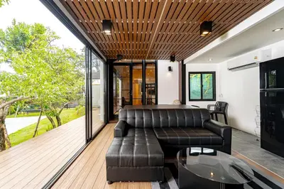 a living room with a leather couch and a table at The Lodge Bangkok Poolvilla in Sathani Khlong Tan
