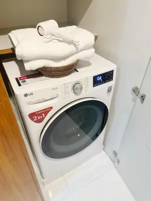 a white washing machine with towels on top of it at 2 Bed 2 Bath Phrom Phong BTS in Bangkok
