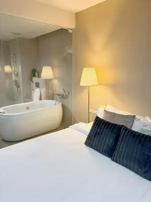a bedroom with a large bed and a bath tub at 2 Bed 2 Bath Phrom Phong BTS in Bangkok