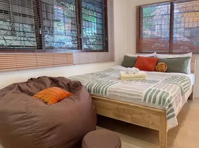 a bedroom with two beds and a bean bag chair at Tiny Cozy Room - Wat Arun in Bangkok