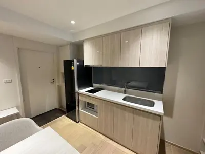 a kitchen with a sink and a black refrigerator at Paradise condo-perfect location in Bangkok