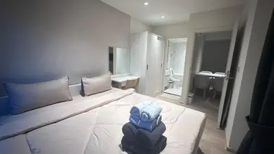 a hotel room with a bed with a person sitting on it at Paradise condo-perfect location in Bangkok
