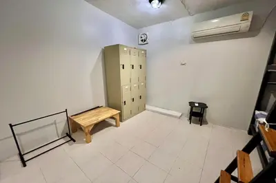 an empty room with a locker and a bench at Orchid Hostel Near Bumrungrad hospital and Nana Market in Bangkok