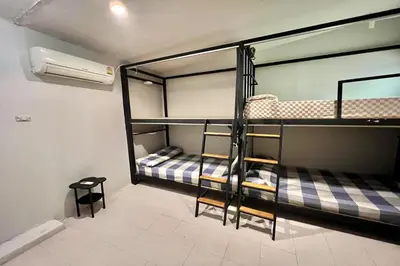 two bunk beds in a room with a fan at Orchid Hostel Near Bumrungrad hospital and Nana Market in Bangkok