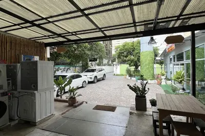 a patio with cars parked in a parking lot at Orchid Hostel Near Bumrungrad hospital and Nana Market in Bangkok