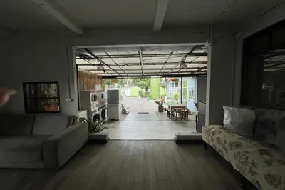 a living room with a couch and an open door at Orchid Hostel Near Bumrungrad hospital and Nana Market in Bangkok