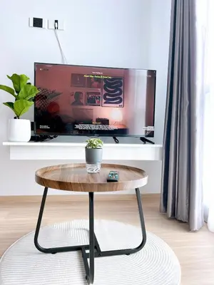 a coffee table in a living room with a tv at Wonderful Stay BTS Ratchayothin in Bangkok