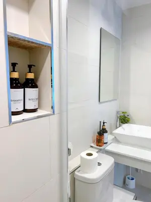 a white bathroom with a toilet and a sink at Wonderful Stay BTS Ratchayothin in Bangkok