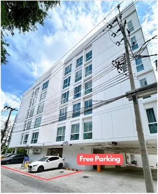 a white car parked in front of a white building at Wonderful Stay BTS Ratchayothin in Bangkok