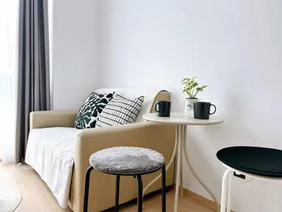 a bedroom with a bed and a table and a stool at Wonderful Stay BTS Ratchayothin in Bangkok