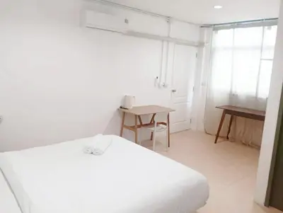 a white room with a bed and a table at xx Mitr INN Sukhumvit 2 - BTS Nana มิตร อินน์ สุขุมวิทซอย 2 บีทีเอส นานา in Bangkok