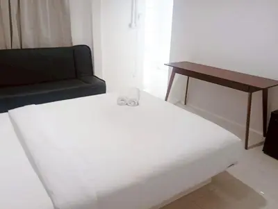 a white bed in a room with a couch and a table at xx Mitr INN Sukhumvit 2 - BTS Nana มิตร อินน์ สุขุมวิทซอย 2 บีทีเอส นานา in Bangkok