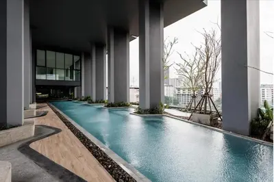 a swimming pool in the middle of a building at Nich Mono Ramkhumheng Low Rise in Sathani Ban Hua Mak