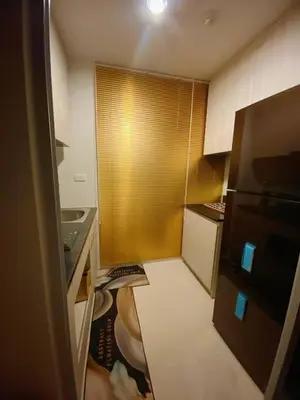 a small kitchen with a refrigerator and a sink at Nich Mono Ramkhumheng Low Rise in Sathani Ban Hua Mak