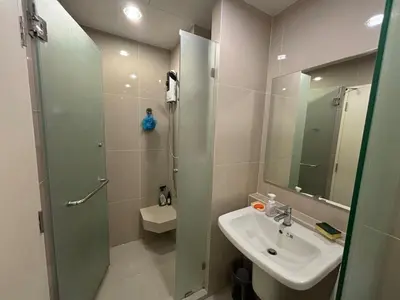 a bathroom with a shower and a sink and a mirror at Nich Mono Ramkhumheng Low Rise in Sathani Ban Hua Mak