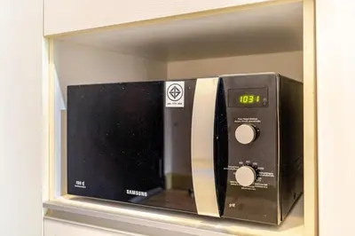 a microwave oven sitting on a shelf in a wall at Super City View Room, Swimming Pool,Gym,150m walk to BTS in Bangkok