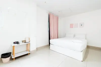 a white bedroom with a bed and a table at XX Oh My Nap- Sukhumvit Soi 3 BTS Nana in Bangkok