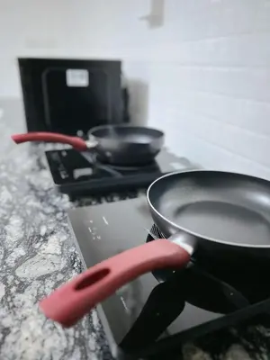 a pan on top of a stove with a red spatula at Near Airport 2nd room for 2,8K & 3rd for 1,8K & 4th only 300B INBOX! in Sathani Ban Hua Mak