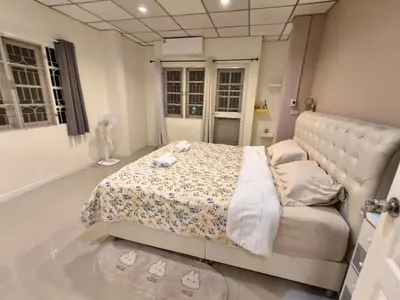 a bedroom with a bed and a couch and windows at Privacy House in Ban Bang Phai