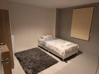 a small bedroom with a bed and a rug at Privacy House in Ban Bang Phai
