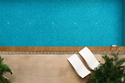 two white chairs sitting next to a swimming pool at King Bed, Park, BTS 5min | Free Parking, Fast WiFi in Khlong Toei
