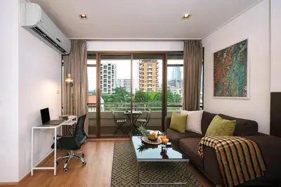 a living room with a couch and a desk and a window at King Bed, Park, BTS 5min | Free Parking, Fast WiFi in Khlong Toei